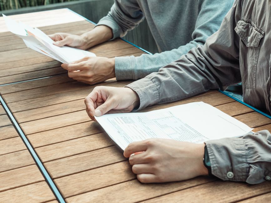 Two professionals reviewing blueprints and discussing project details at a table